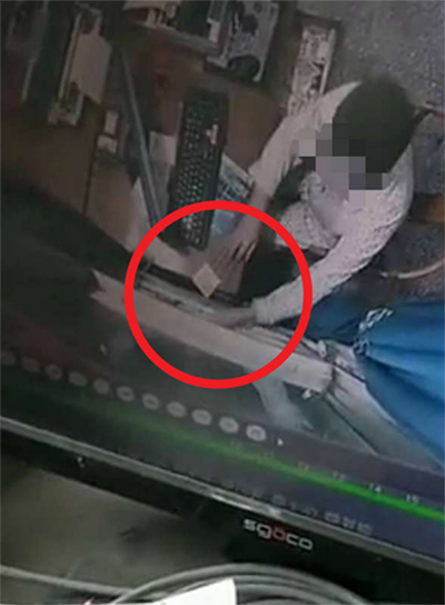 監(jiān)控視頻顯示收費(fèi)員兩次用手將錢(qián)推入夾縫 成都商報(bào) 圖