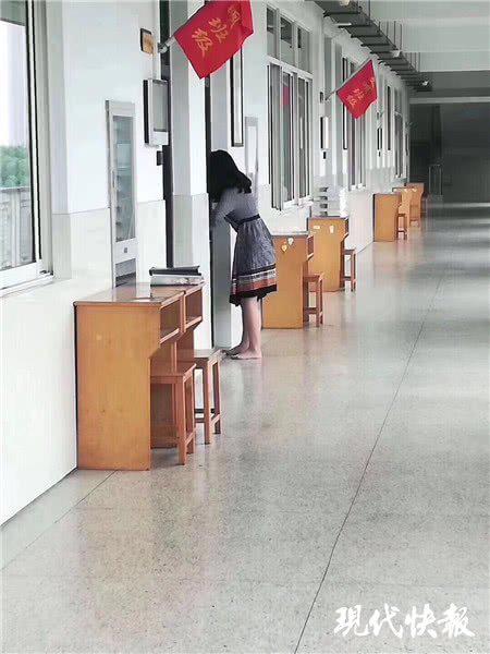 △擔心打擾上課，她脫了高跟鞋赤腳在教室外行走 張春攝