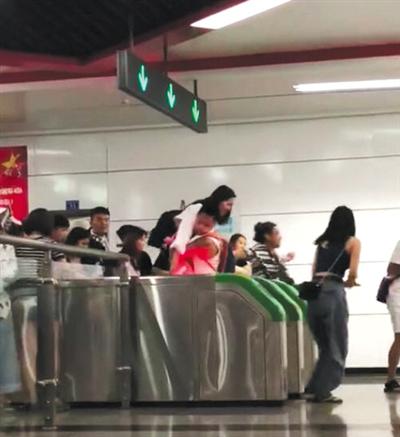 跳 一女子從地鐵檢票閘機口上一躍而下。 視頻截圖