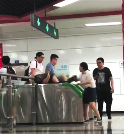 翻 兩男子用雙手撐住地鐵檢票閘機兩側(cè)，縱身翻過閘機口。視頻截圖