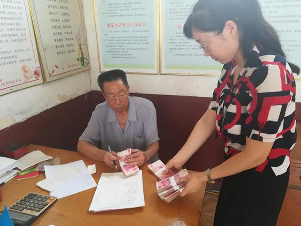 愛心企業(yè)工作人員（右）為田京榮一家送去捐款。