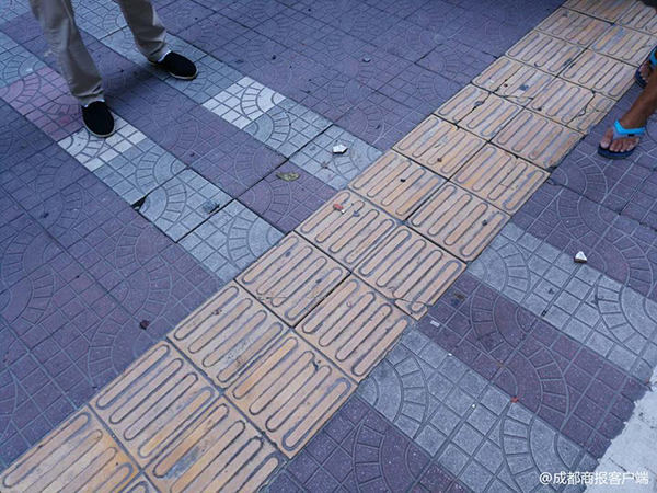  砸中奔馳車后，碎掉的瓷磚散落一地。