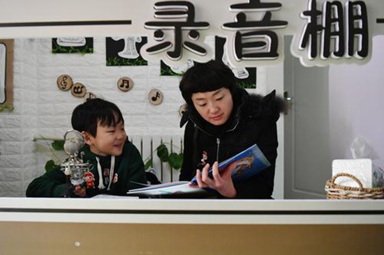 小朋友和家長在錄音棚講故事進行互動。圖片來源新華社