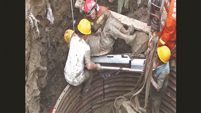 壓在工人身上的水泥塊被綁在挖掘機上吊出
