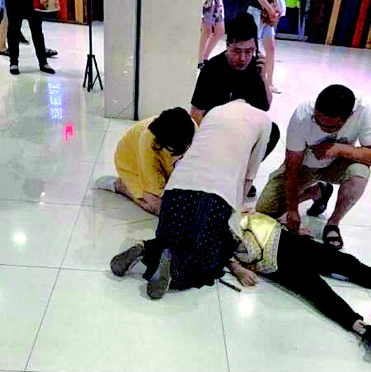 四名醫(yī)務(wù)人員跪在地上實(shí)施急救。壹粉供圖